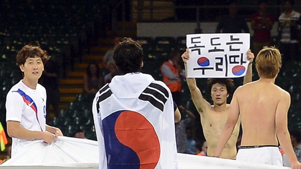 Park Jong-woo_with_political_banner_London_2012